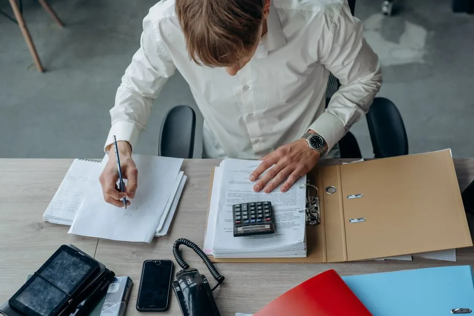 Un dirigeant classe ses factures et ses relevés sur son bureau